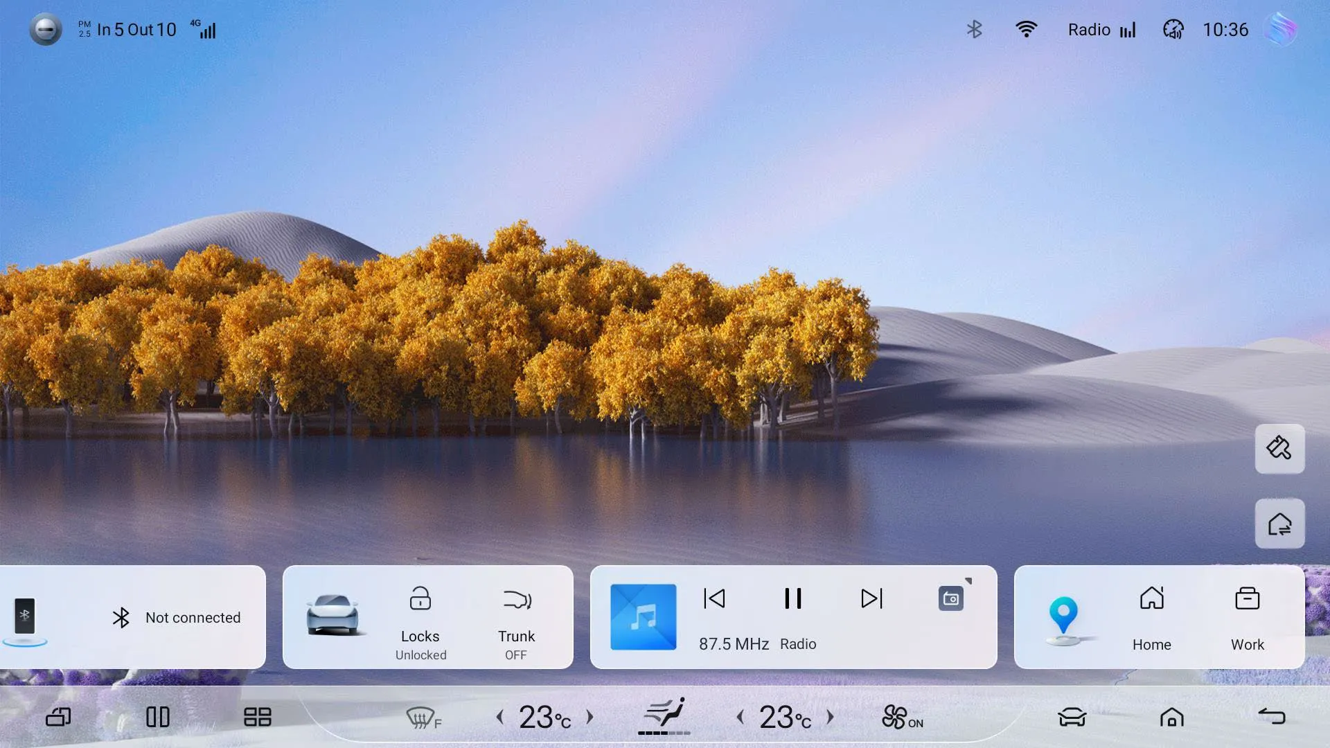 Head-unit home screen with a landscape wallpaper of autumn trees and a lake, a bottom dock with Bluetooth (Not connected), Locks/Trunk vehicle controls, a radio media widget at 87.5 MHz and a navigation widget with Home and Work shortcuts, and a climate bar showing 23 °C.