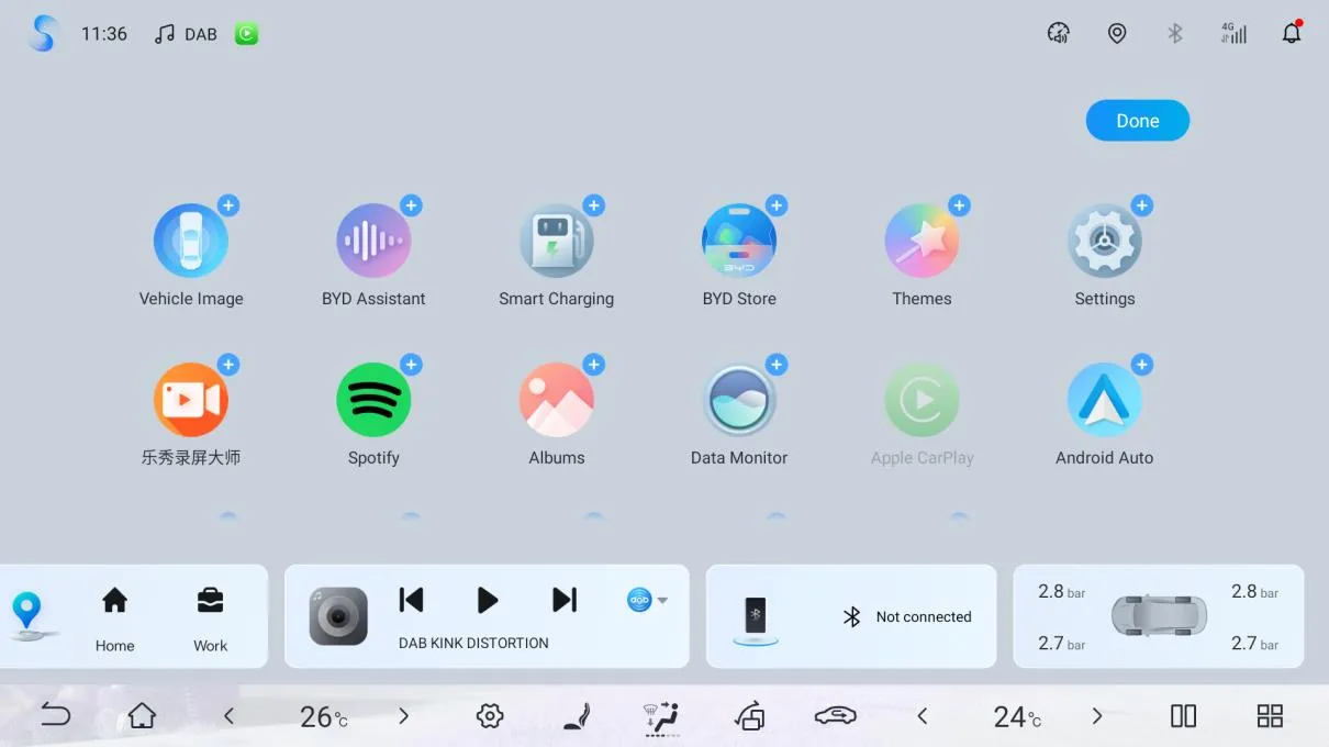 Head-unit app grid in the new UI with a Done button and round icons for Vehicle Image, BYD Assistant, Smart Charging, BYD Store, Themes, Settings, a screen-recorder app, Spotify, Albums, Data Monitor, Apple CarPlay (greyed out) and Android Auto, each with a blue plus badge for adding it to the desktop.