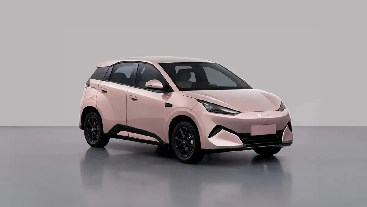 The BYD Great Seagull in pale pink, photographed in three-quarter front view in a studio, with a closed grille, slim swept headlights and black wheels