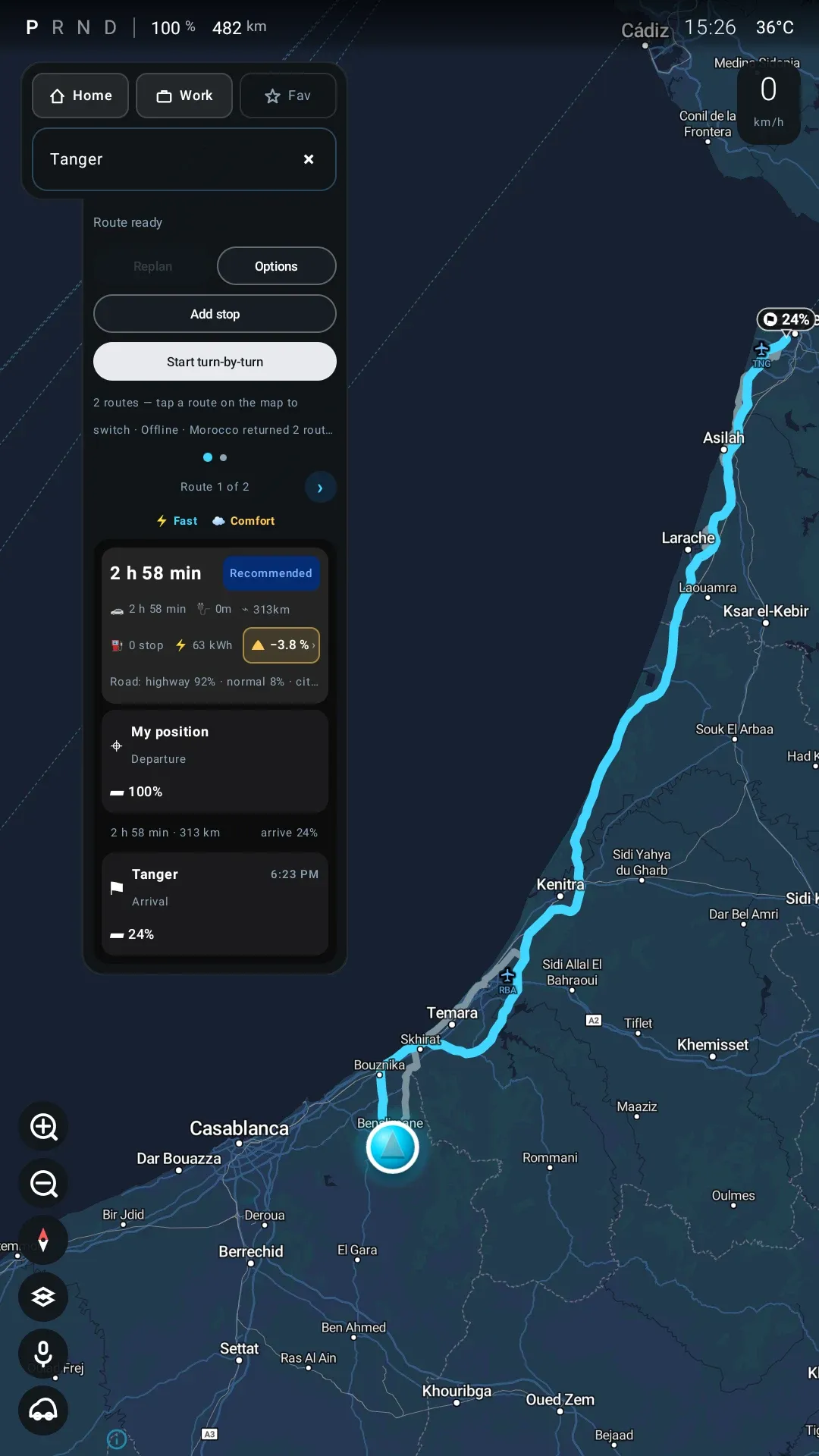 A planned route from Benslimane to Tanger on the head unit: 313 km, 2 h 58, arrive 24 %, with an amber terrain pill reading minus 3.8 percent.